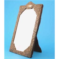 A Victorian silver mounted easel mirror, decorated with a cartouche shaped crest and overall scro...