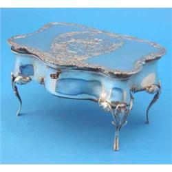 An Edwardian silver jewellery box modelled as an 18th century serpentine table, the hinged lid de...