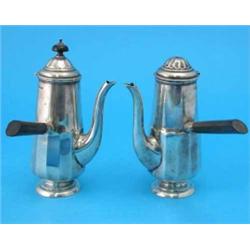 A pair of George V silver cafe au lait pots, with ebony finial and handles and chamfered decorati...