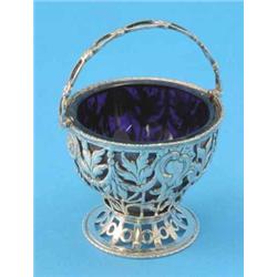 A George III pierced silver sugar basket, with blue glass liner and decorated throughout with flu...