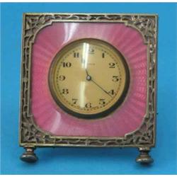 A George V silver and pink enamel timepiece, decorated with a pierced and engraved foliate bands...