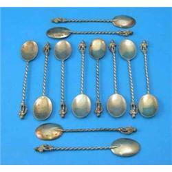 A set of 12 Victorian silver gilt teaspoons, each finial modelled as putti holding a serpent on s...