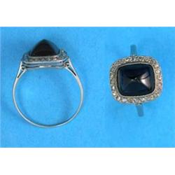 A platinum ring, set with a rectangular cabochon-cut sapphire within a border of rose-cut diamond...