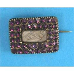 A Victorian gold rectangular mourning brooch, with hair compartment surrounded by 2 rows of ameth...