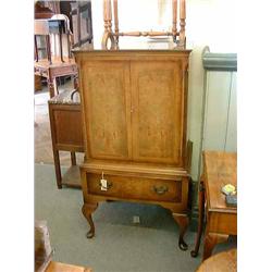A walnut and feather-banded side cupboard, on cabriole legs, H 126cms W 65cms...