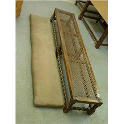 A beech footstool with barleytwist underframe and cane top, H 24cms L 152cms...