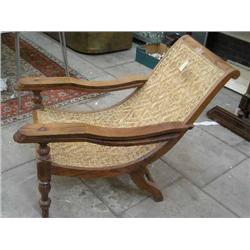 A teak planter's caned chair...