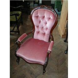 A Victorian carved walnut deep-buttoned open armchair...