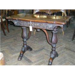 An Irish Victorian carved oak and walnut card table with shaped folding top, H 74cms W 93cms...