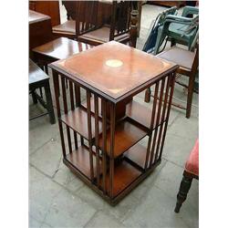 A mahogany revolving crossbanded and inlaid bookcase, H 80cms W 49cms...
