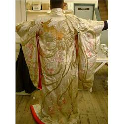An early 20th century Japanese silk-embroidered wedding kimono decorated with a peacock in a peon...