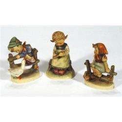 Three Hummel figures of a young girl writi…