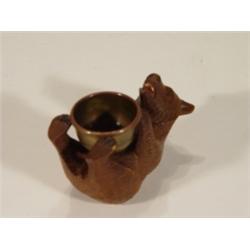 Carved Black Forest bear clutching a brass…