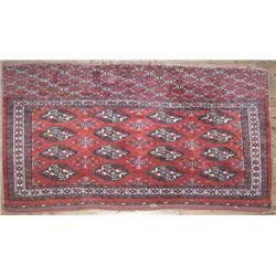 A Bokhara red ground saddle cover, woven four rows of elephants feet, 3ft 6ins x 2ft 8ins...