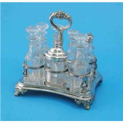 A Victorian plated cruet stand, with five facetted glass bottles and stoppers and silver topped m...