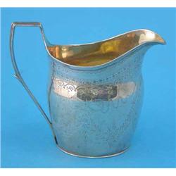 A George III silver cream jug, decorated with engraved foliate swags and wrigglework bands, Londo...