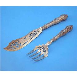 A pair of Victorian pierced silver fish servers, with engraved foliate decoration and neo-rococo...