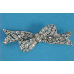 A 1930's platinum and diamond brooch, designed as a loosely tied ribbon, 2.25ins...