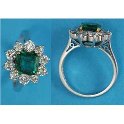 An emerald and diamond ring, claw-set in 18ct white gold with a square-cut emerald bordered by 10...