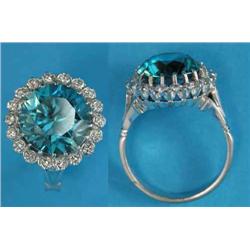 A blue zircon and diamond circular cluster ring, claw-set in 18ct white gold...