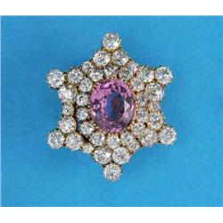 An Edwardian pink topaz and diamond gold mounted brooch/ pendant, claw-set at the centre with an...