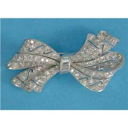 A diamond bow brooch, of piercework design set brilliant and baguette cut diamonds, 1.75ins...