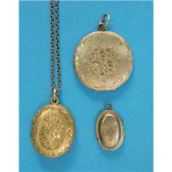 A Victorian foliate engraved oval locket, a small oval Georgian memorial locket and a circular go...
