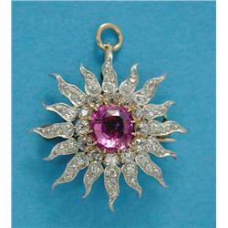 A pink sapphire and diamond 'rising sun' brooch/pendant, claw-set with a central cushion shaped p...