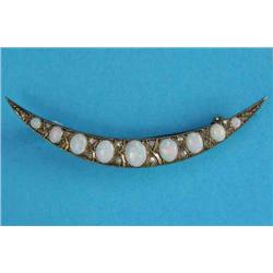 A Victorian gold open crescent brooch, set 9 graduated oval opals and diamond chips...