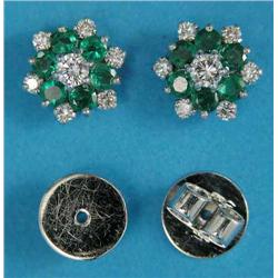 A pair of emerald and diamond cluster earrings, each claw-set in white gold with a central diamon...
