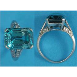 A white gold dress ring, claw-set with a rectangular cut blue zircon, the split shoulders set sma...