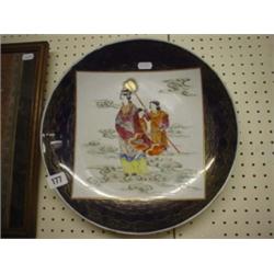 Large oriental saucer dish with hand painted scene on blue and gilded ground 13.5" diameter