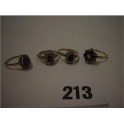 Four dress rings, stone sets are garnet, amethyst etc