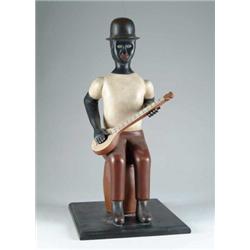 FOLK ART CARVED SEATED BLACK MINSTREL BY HOWARD ANDERSON.