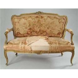 CARVED AND GILT UPHOLSTERED OPEN ARM FRENCH STYLE SOFA.