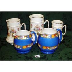Set of three graduated Crown Devon jugs  8", 7" and 6" high plus two other graduated jugs
