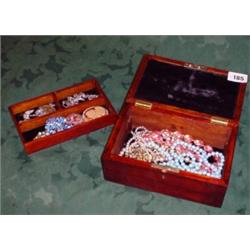 Small mahogany trinket containing decorative costume jewellery, brooches etc.