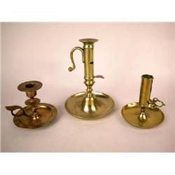 A GROUP OF THREE BRASS CHAMBERSTICKS ENGLISH AND CONTINENTAL