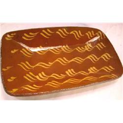 A COMB-DECORATED REDWARE LOAF DISH