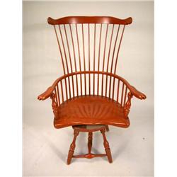 A DUCKLOE REVOLVING SALMON-PAINTED, COMB BACK WINDSOR-AVON CHAIR.