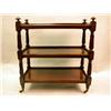 Image 1 : A VICTORIAN MAHOGANY THREE-TIERED ROLLING BOOKSHELF