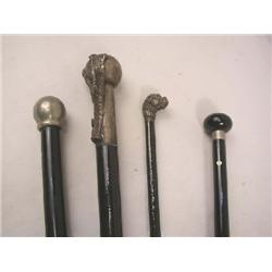A GROUP OF FOUR EBONIZED WALKING STICKS