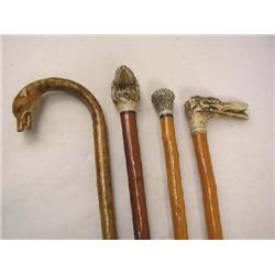 A GROUP OF FOUR WALKING STICKS