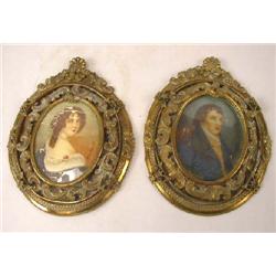 A PAIR OF PORTRAIT MINIATURES IN OVAL BRASS REPOUSSE FRAMES