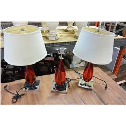 THREE RED GLASS TABLE LAMPS