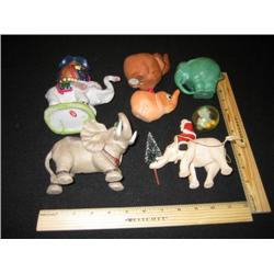Seven elephants, two are cactus planters, one is a little elephant car in a plastic bubble, the gree