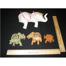 Four elephants, the large one in the rear is a sleepy and hangs over the ledge. The three in the fro