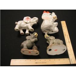 Four elephants, two are porcelain, two are ceramic, nice grouping.