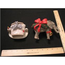 Two little elephants snuggled in bed with their friend the holiday elephant.