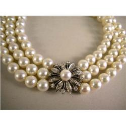 A THREE STRAND PEARL NECKLACE WITH PLATINUM OVER GOLD PEARL AND DIAMOND FLORA-FORM CLASP